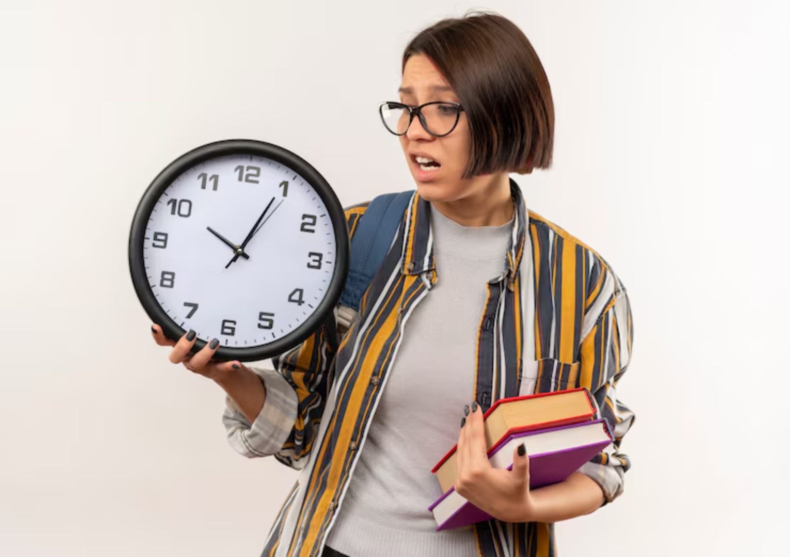 A person holds a large wall clock in one hand and colorful books in the other, dressed in a striped shirt against a plain background.